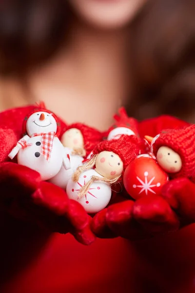 Pequeno boneco de neve com cachecol vermelho e chapéu nas mãos de um modelo. Ch... — Fotografia de Stock