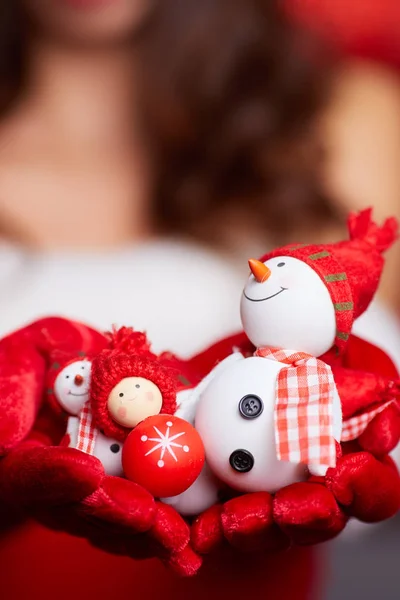 Small snowman with red scarf and hat at the hands of a model. Ch — Stock Photo, Image