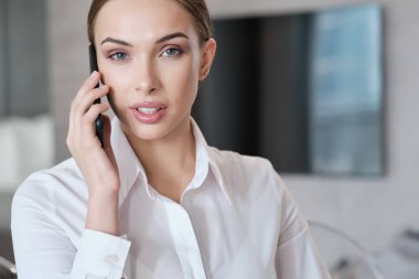 yatakta oturan bir dizüstü bilgisayar üzerinde çalışan rahat güzel kadın