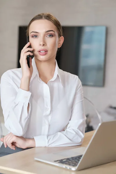 Casual mooie vrouw werken op een laptop zittend op het bed in — Stockfoto