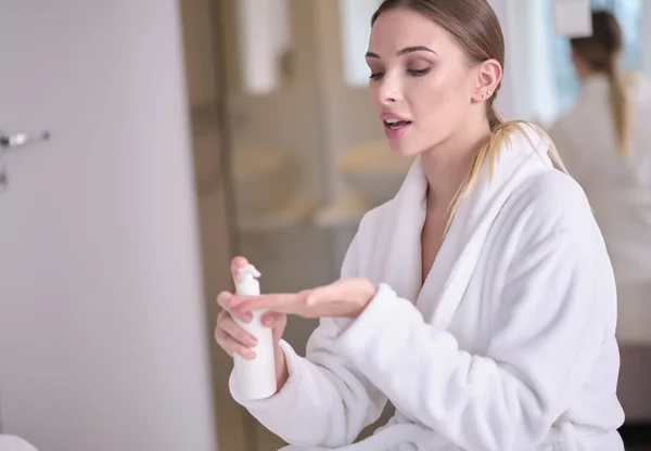 Hermosa mujer joven después del baño aplicando crema corporal sobre la piel un — Foto de Stock