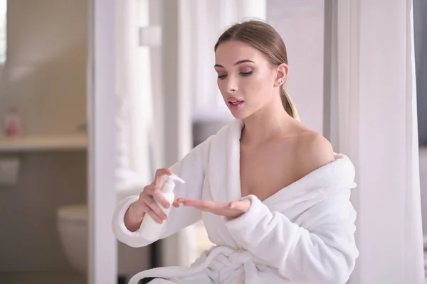 Beautiful young woman after bath applying body cream onto skin a — Stock Photo, Image