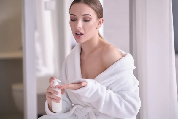 Beautiful young woman after bath applying body cream onto skin a — Stock Photo, Image