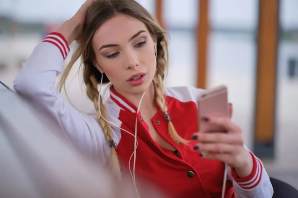 Mujer joven atractiva escuchando música en los auriculares, mirando — Foto de Stock