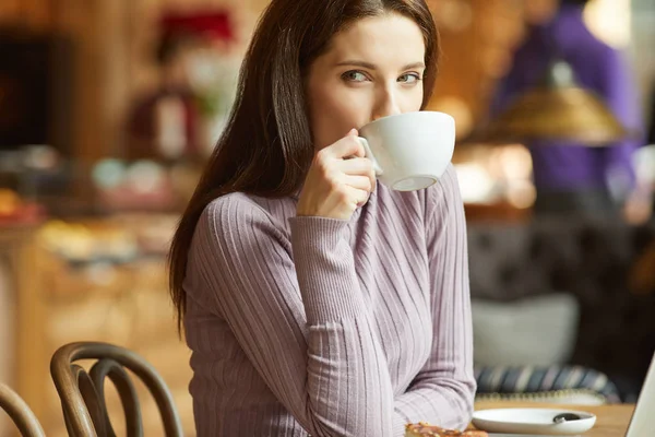 Beautiful young woman with a cup of tea at a cafe — Stock Photo, Image