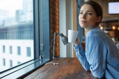 Açık uzay ofisinde dizüstü bilgisayarda çalışan bir kadın 