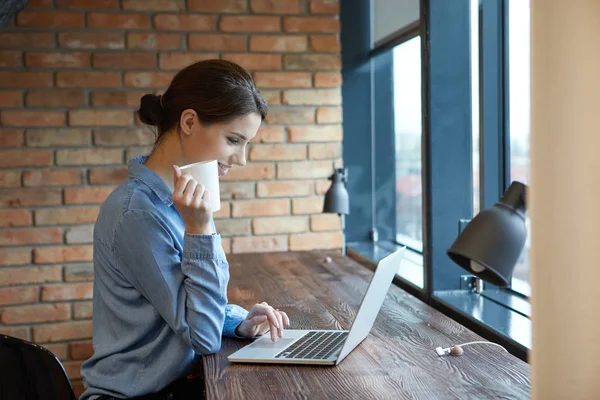 Mulher trabalhando no laptop no escritório de espaço aberto — Fotografia de Stock
