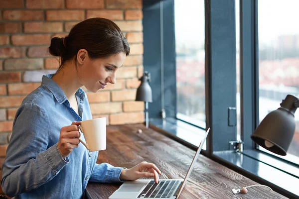 Mulher trabalhando no laptop no escritório de espaço aberto — Fotografia de Stock