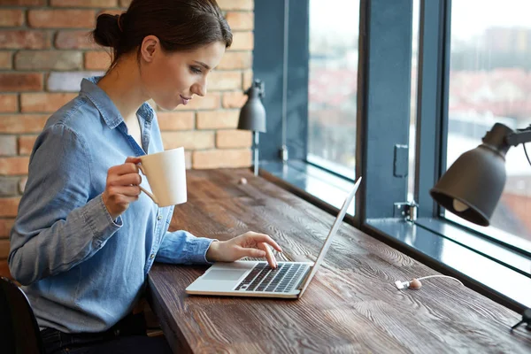 Mulher trabalhando no laptop no escritório de espaço aberto — Fotografia de Stock