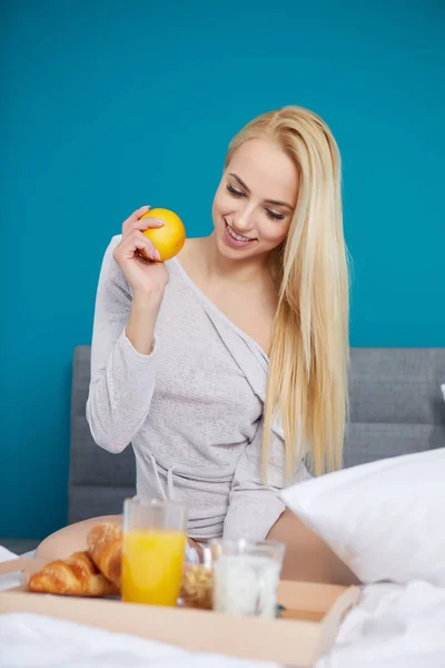 Ung vacker kvinna med kopp juice i sängen — Stockfoto