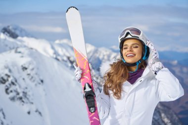Maske takan ve elinde tutan güzel kayakçı kız portresi.