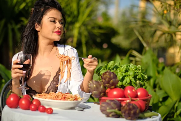 Schöne Frau im Sommerkleid isst italienische Spaghetti mit — Stockfoto