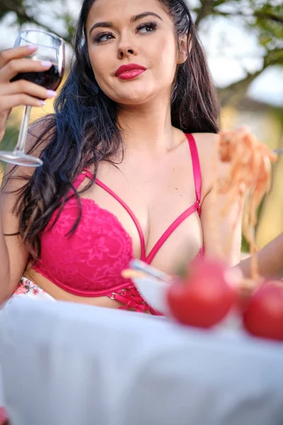 Όμορφη γυναίκα σε καλοκαιρινό φόρεμα τρώει Ιταλία μακαρόνια με ζυμαρικά — Φωτογραφία Αρχείου