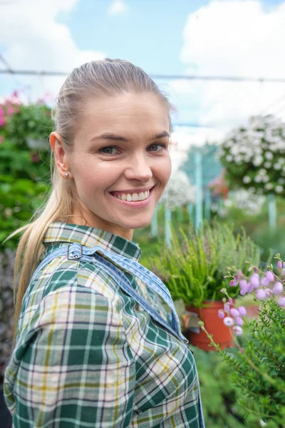 Gelukkig vrouw tuinman kiezen bloempot met anthuriums in gar — Stockfoto