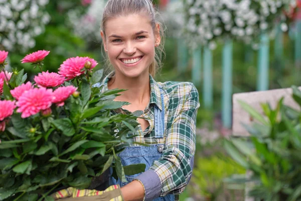 Floristas mujer trabajando con flores en un invernadero. —  Fotos de Stock