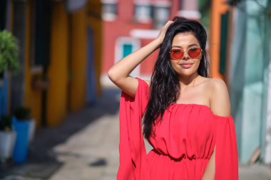 traveler woman posing among colorful houses on Burano island, Ve