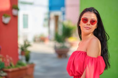 traveler woman posing among colorful houses on Burano island, Ve