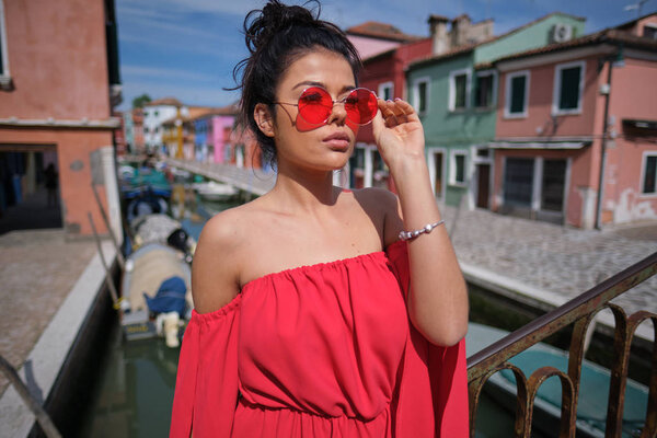  Молодая модная женщина в романтическом красном платье с косичками
