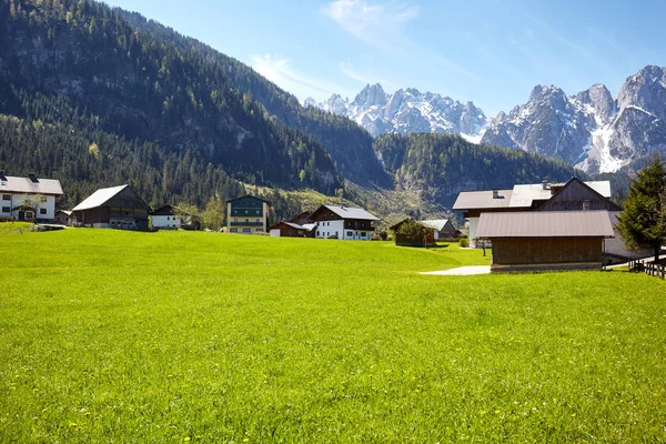 Vidéki út vezet az alpesi házak, a háttérben — Stock Fotó