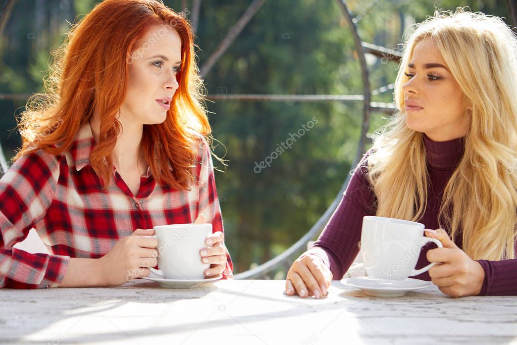 Two friends woman  talk and drink coffee on the terrace