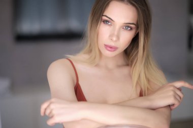  Neşeli, sarışın, sıradan giyinmiş, kameraya bakarak mutlu olan bir kadın. Güzel bir kadının ev fotoğrafı.