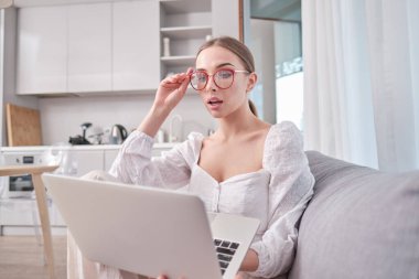 Koronavirüs salgını. Ofiste çalışırken dizüstü bilgisayara bakan kadın. . 