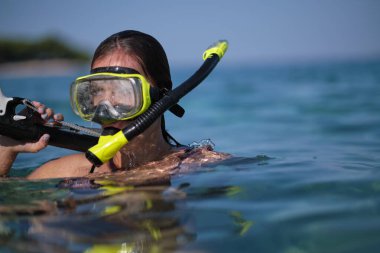 Bikinili bir kadın yaylı tüfekle avlanır.