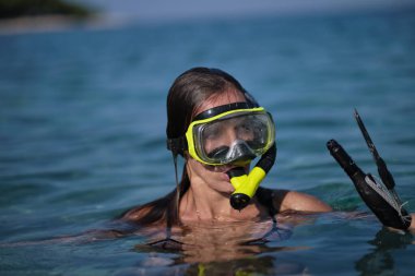 Bikinili bir kadın yaylı tüfekle avlanır.