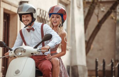 Mutlu genç çift gün batımında veya gün doğumunda mobiletle gezerken eğleniyor. Motosikletli çift