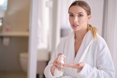 Evde bornozlu bir kadın dinleniyor.