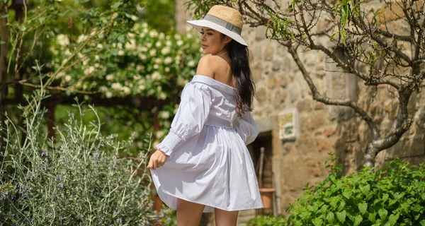 Italian woman in white  dress in the fabulous garden in Italy. Vogue fashion style portrait of brunette model