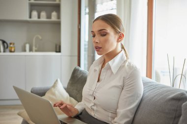 Merkez ofiste dizüstü bilgisayarla çalışan konsantre genç ve güzel bir iş kadını. adlolasyon, virüs konsepti