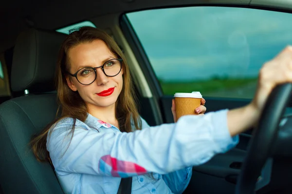 Mujer con café para ir conduciendo su coche —  Fotos de Stock