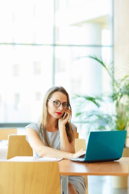 Çalışma ile bir dizüstü bilgisayar ve cep telefonuyla konuşan kadın