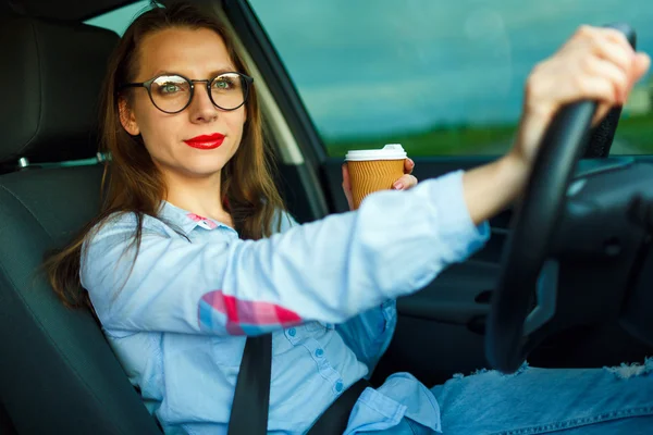 Mulher com café para ir dirigindo seu carro — Fotografia de Stock