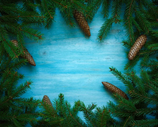 Gałęzi choinki z szyszki na niebieski drewniane tekstury gotowe — Zdjęcie stockowe