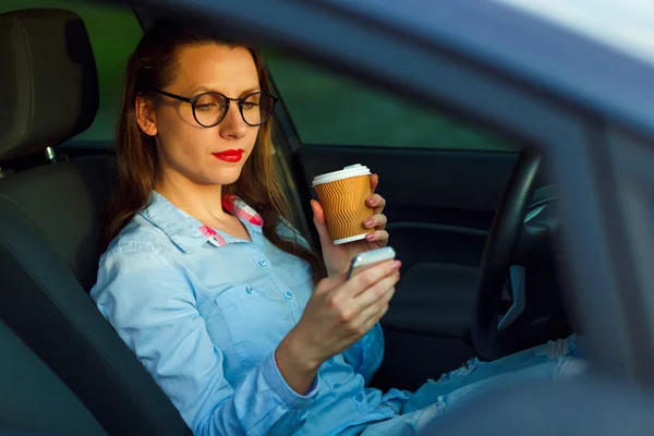 Empresária enviando uma mensagem de texto e beber café enquanto d — Fotografia de Stock