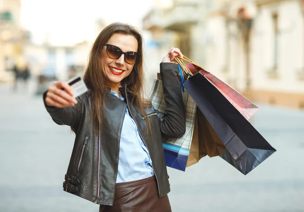 Mulher bonita com sacos de compras e cartão de crédito nas mãos — Fotografia de Stock