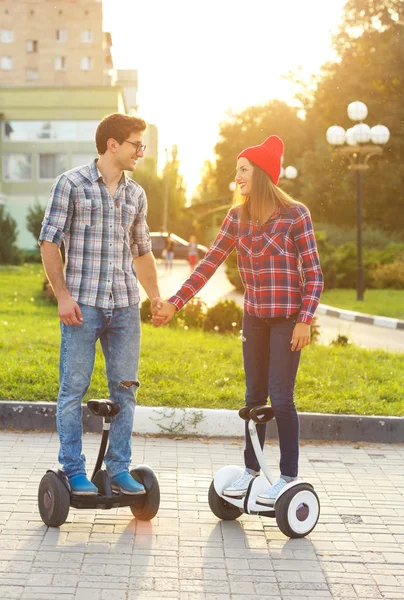 Pareja joven montando hoverboard — Foto de Stock