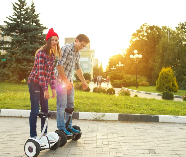 Young couple riding hoverboard — Stock Photo, Image