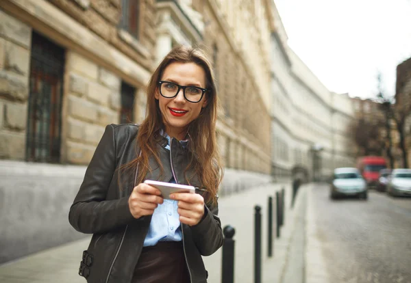 Mujer de negocios caminando por la calle mientras habla en pho inteligente — Foto de Stock