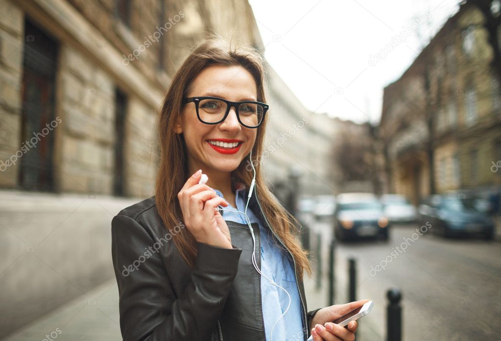 Businesswoman walking down the street while talking on smart pho