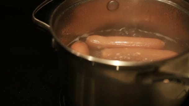 沸腾的热狗。在热水中煮香肠 — 图库视频影像