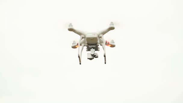 Drone branco, quadrocopter, com câmera fotográfica voando no céu azul — Vídeo de Stock