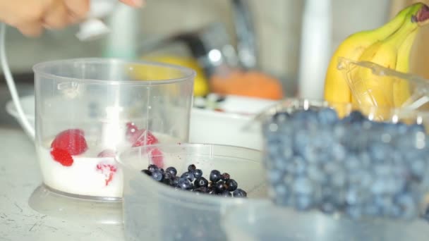 Zubereitung Smoothie mit Erdbeeren, Banane, Blaubeeren und Milch — Stockvideo