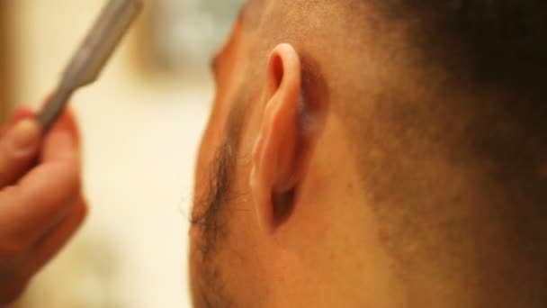 Frisör gör frisyr av attraktiv man i barbershop — Stockvideo