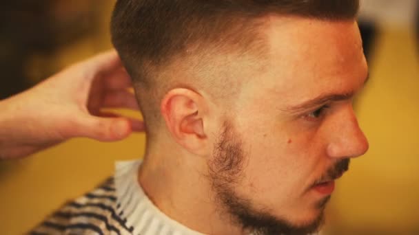 Peluquero haciendo corte de pelo de hombre atractivo en la barbería — Vídeos de Stock