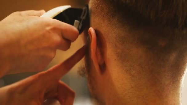 Barbeiro fazendo corte de cabelo de homem atraente na barbearia — Vídeo de Stock