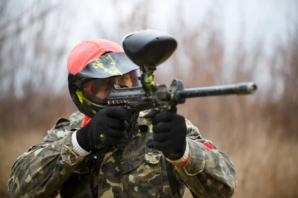 Paintball sport player wearing protective mask and aiming gun — Stock Photo, Image