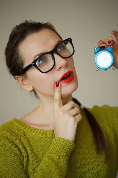 생각에 잠겨있는 젊은 여자의 손에서 작은 파란색 알람 시계 — 스톡 사진
